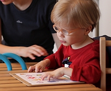 Ein Junge lernt anhand von Bildern lesen.